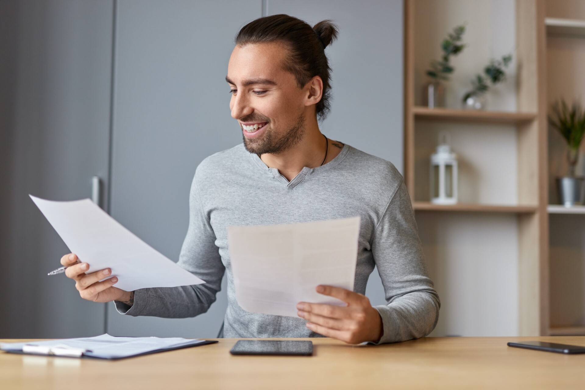 Smiling male working with documents at home