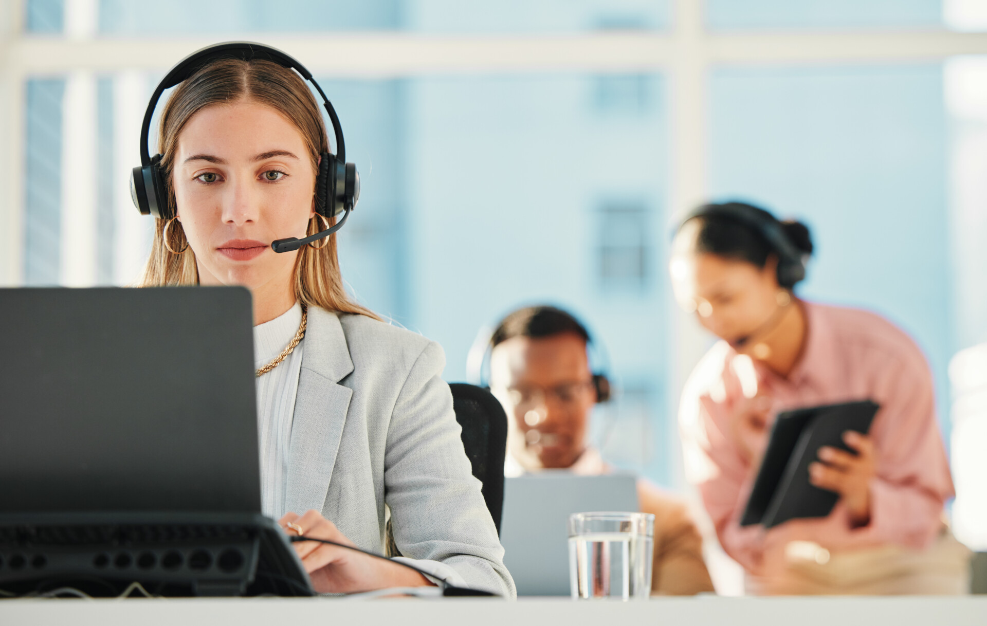 Call center, woman and agent at laptop for telemarketing, customer service or IT support in coworki