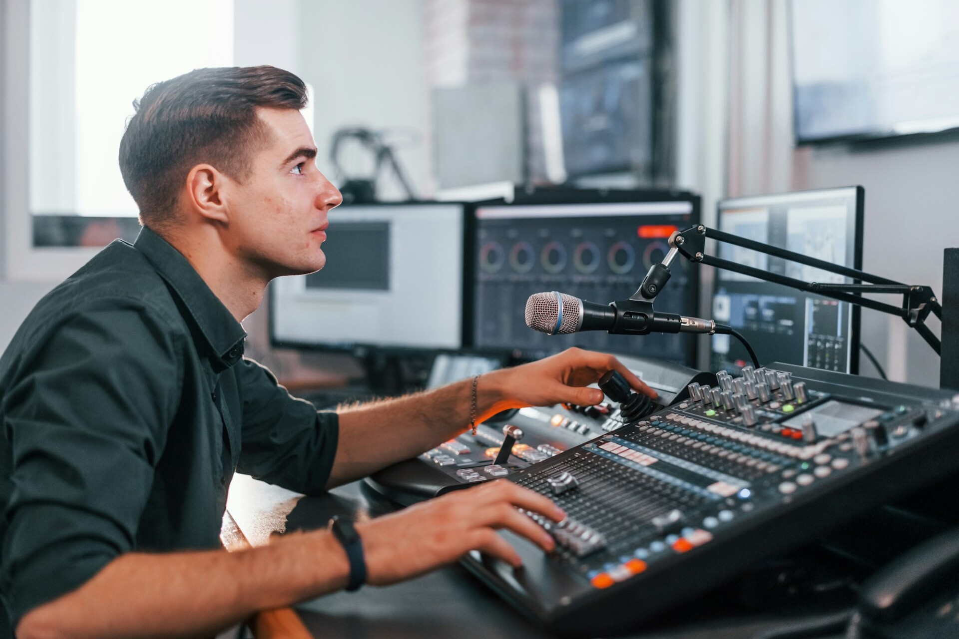 Young man is indoors in the radio studio is busy by broadcast