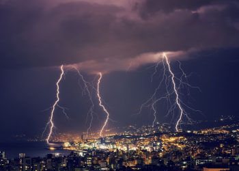 Beautiful lightning at night over gorgeous glowing Lebanon, majestic nighttime cityscape, stormy weather