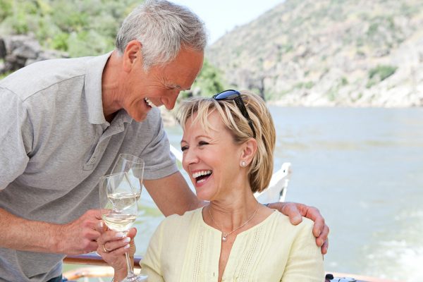 Senior couple with glasses of wine on a boat holiday